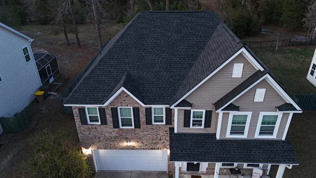 Aerial view of a two-story home with a new dark architectural shingle roof
