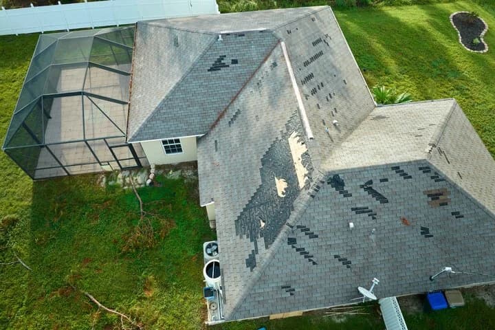 Aerial view of a roof that's been heavily damaged by a recent storm