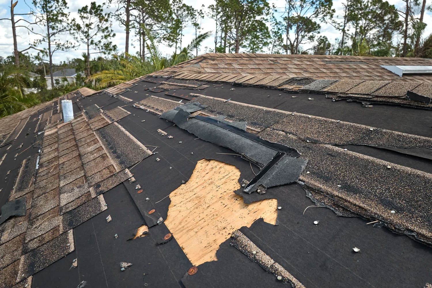 Damaged house roof with missing shingles.